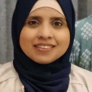 Portrait of a professional female staff member wearing a blue hijab and smiling at Dandenong Dental Care.